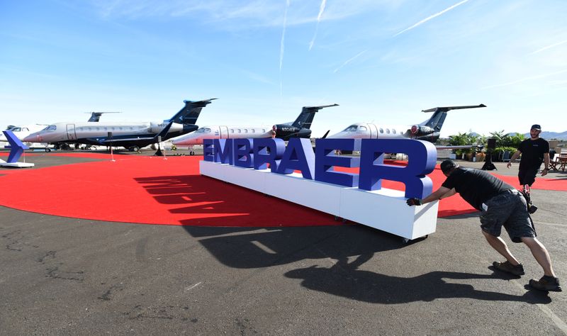 Funcionários ajeitam letreiro da Embraer (EMBR3) durante exposição em Las Vegas - David Becker, para a agência Reuters