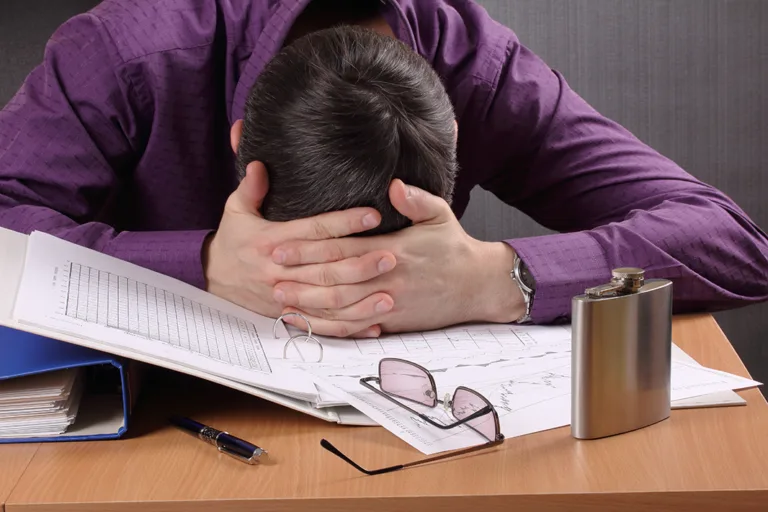 man tired of work, bowed his head to table with documents