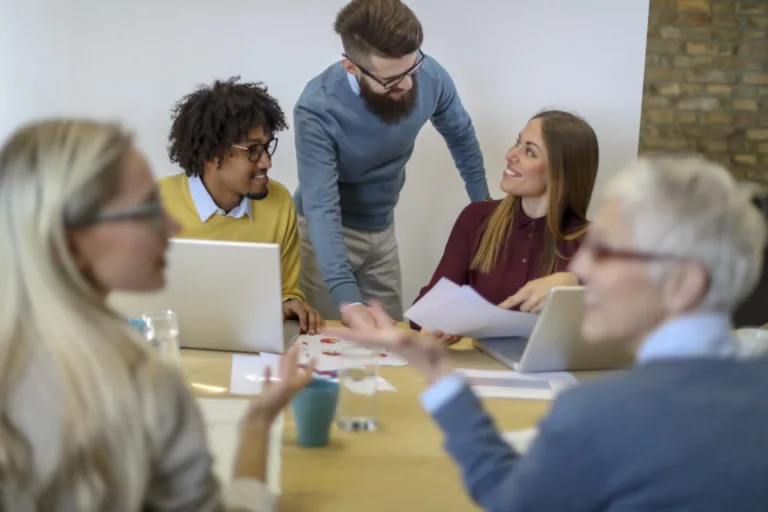 Beautiful, smiling and young colleagues at the meeting are working on the presentation and conversations in the conference room