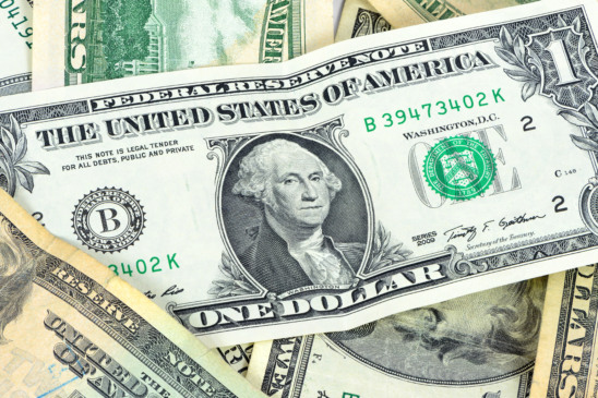 Dólar hoje em queda. Imagem de uma nota de 5 dólares com a bandeira dos EUA, ilustrando a baixa da moeda americana em relação ao real, influenciada pela expectativa de corte de juros pelo Fed.