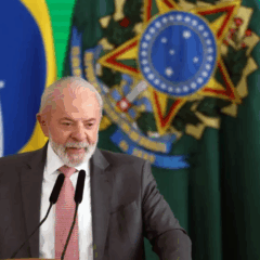 Foto de Lula com fundo da bandeira do Brasil e Donald Trump com fundo da bandeira dos Estados Unidos. O texto da imagem descreve a negociação comercial e a Lei da Reciprocidade.