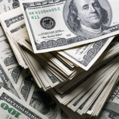 Pilha de notas de 100 dólares americanos empilhadas, destacando riqueza e finanças.