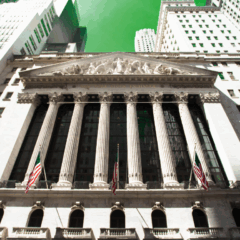 Fachada de Wall Street com bandeira dos EUA representando Bolsas de NY em recorde.