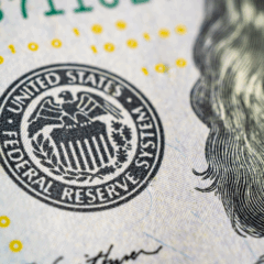 Símbolo do Federal Reserve em nota de dólar, representando expectativa de corte de juros pelo Fed.
