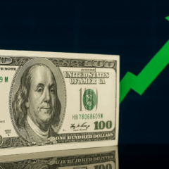 Cédula de 100 dólares com seta verde apontando para cima ao fundo, representando alta do dólar.