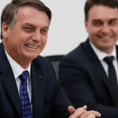Jair Bolsonaro e Flávio Bolsonaro sorrindo em reunião, associados à reação negativa do mercado financeiro.