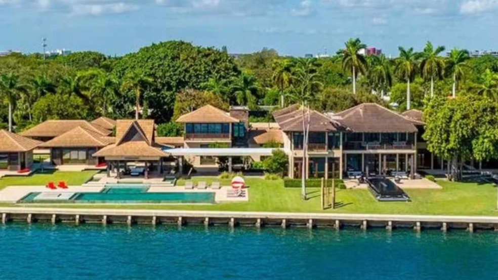 Vista aérea da mansão de Daniel Vorcaro em Miami, com piscina e frente para a baía.