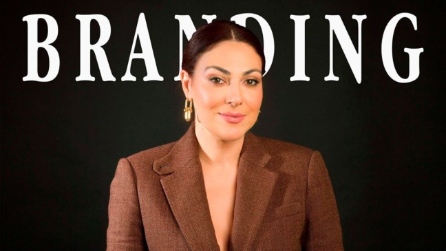Retrato de Francini Covelli, executiva de branding, em fundo escuro com a palavra “Branding” ao fundo, vestindo blazer marrom e olhando para a câmera